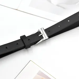 Minimalist black thin leather belt detail, silver square buckle, versatile dress waist accessory.