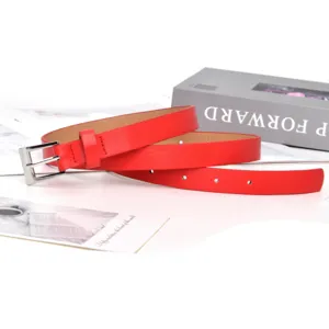 Close-up detail of a minimalist red leather belt featuring a sleek silver square buckle.