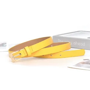 Close-up detail of a bright yellow women's thin belt with a metallic square buckle.