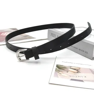 Detail shot of women's minimalist black PU leather belt with silver buckle for jeans.