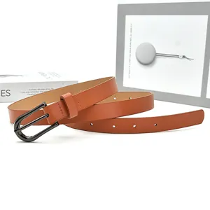 Détail de ceinture en cuir marron, design minimaliste avec boucle en métal foncé élégante.