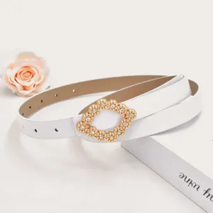 Close-up van een stijlvolle witte riem met een sprankelende gouden strass-gesp.