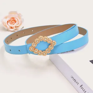 Gedetailleerd overzicht van lichtblauwe smalle damesriem met elegante gouden strass gesp.