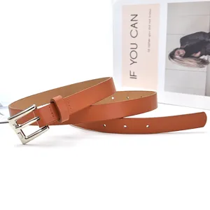 Detailed view of women's brown leather belt with silver pin buckle, simple fashion accessory.