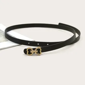 Detailed shot of a black thin leather belt with a gold metal bow buckle for women stylish look.