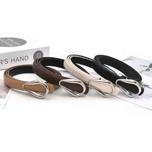 Close-up of four thin PU leather women's belts with metal horseshoe buckles in multi colors.