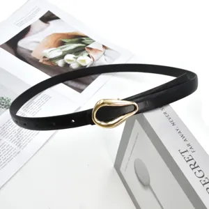 Black thin PU leather belt with gold horseshoe buckle, minimalist detail view for women dress.