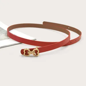 Detailed view of a red thin leather belt featuring a chic gold heart-shaped buckle design.