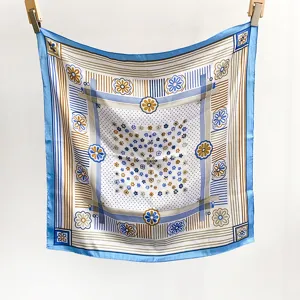Vue de détail du carré de soie synthétique florale française avec bordure bleue et motif rayé.