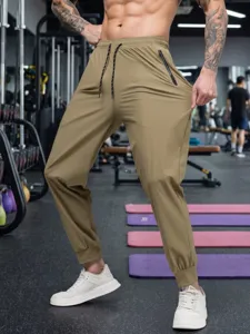 Detailed view of men's quick-dry gym jogger pants showcasing athletic fit in a gym.
