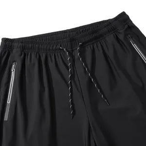 Close-up detail of mens black athletic quick dry shorts waistband with secure zipper pockets.