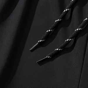 Men's quick dry pants detailed view, black athletic jogger pants fabric and drawstring.