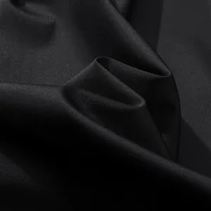 Close-up view of black quick-drying fabric showing fine texture and elastic stretch folds.