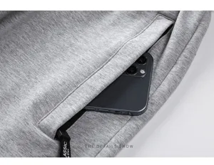Detalle de bolsillos de pantalones cortos deportivos de hombre, tela gris con cremallera.