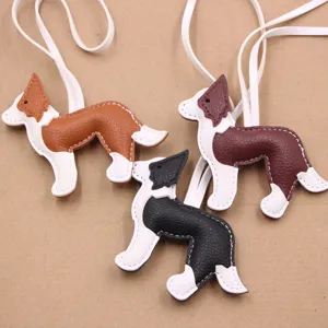 Gros plan détail de pendentifs de sac chien en cuir, design multicolore avec lanière.