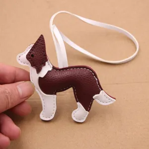 Vue detaillee de pendentif de sac chien en cuir, accessoire marron et blanc pour sacs.