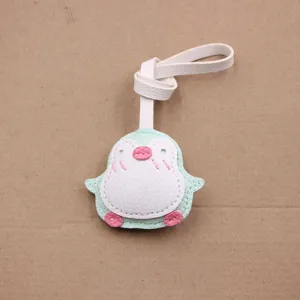 Adorable pendentif de sac pingouin en cuir, détail artisanal pour accessoires de mode.