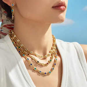 Mehrlagige goldfarbene Kette und Ohrringe Set mit bunten gefassten Zirkoniasteinen Detail.