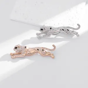 Broche léopard élégante pavée de strass en argent et or rose, accessoire animalier de luxe.