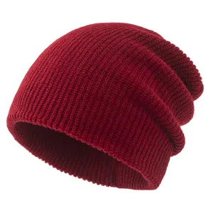 Close-up of the soft red knit beanie texture, showing warm winter slouchy cap fabric details.