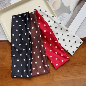 Detail view of elastic polka dot wide headbands in assorted colors for workout and yoga.