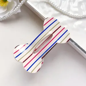 Close-up van een schattige botvormige haarspeld met kleurrijke strepen, stijlvol haaraccessoire.