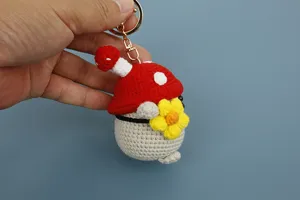 Vista dettagliata del portachiavi pinguino fungo all'uncinetto borsa di peluche.