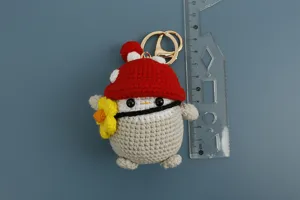 Dettaglio portachiavi pinguino fungo all'uncinetto, grazioso ciondolo con fiore.