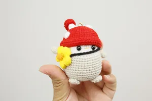 Vista dettagliata del morbido peluche pinguino a forma di fungo lavorato a mano con cura.