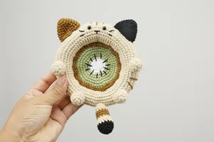 Gedetailleerd close-up van handgemaakte gehaakte kattenonderzetter met kiwi fruit ontwerp.