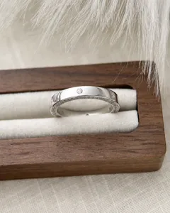 Gros plan bague argentée sertie de strass, design luxueux, détails étincelants élégants.