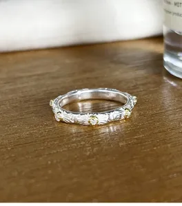 Gros plan détaillé de la bague marguerite en argent sterling S925 avec finition bicolore élégante.