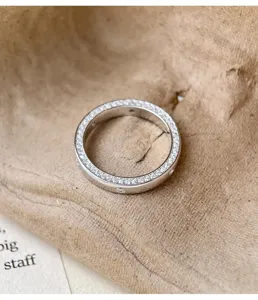 Détail de bague pavée en argent, montrant des pierres étincelantes et une finition exquise.