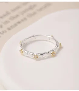 Gros plan détail de la bague marguerite en argent S925, bloc couleur or et argent.