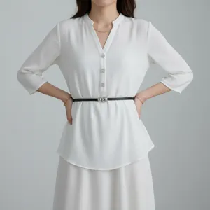 Minimalistική δερμάτινη ζώνη με μεταλλική σφαίρα, λεπτομέρεια σε λευκό τοπ και φούστα.
