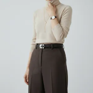 Minimalist women's black leather belt paired with chic brown casual trousers outfit.