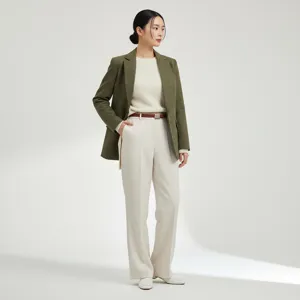 Women's professional casual outfit featuring a green quilted blazer, white sweater and trousers.