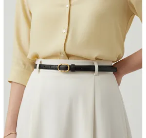 Gros plan détaillé de la ceinture fine noire élégante avec boucle métallique dorée femme.