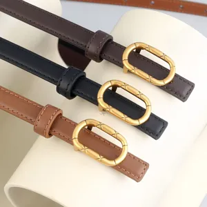 Vue détaillée d'une fine ceinture en cuir pour femme avec boucle ovale dorée et coutures.