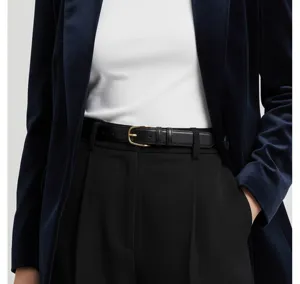 Detaillierte Nahaufnahme eines eleganten schwarzen Damen-Ledergürtels mit goldener Metallschließe.