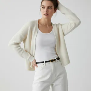Close-up detail of a minimalist black leather belt with elegant metallic buckle on pants.