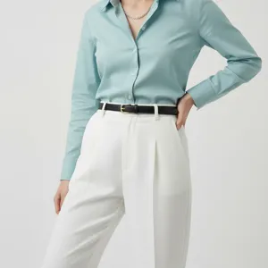 Close-up detail shot of women's minimalist genuine leather belt worn with trousers.