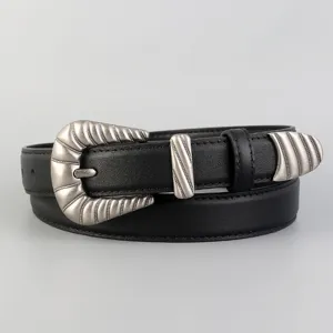 Detailed close-up of a black leather women belt with vintage silver western engraved metal buckle.