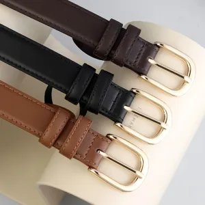 Close-up of minimalist women leather belts in brown, black, and tan with gold buckles.