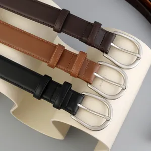Classic leather belt detail shot showcasing three colors with metal buckles and neat stitching.