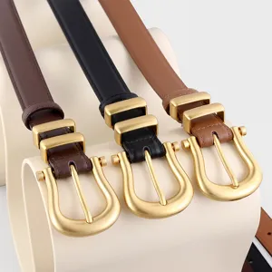 Close-up detail of stylish women's leather belts featuring elegant gold U-shaped buckles.