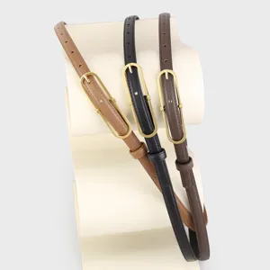 Detail shot of three slim leather belts in brown, black and dark brown with metal buckles.