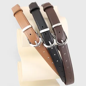 Detail shot of three classic women leather belts in camel black and dark brown with silver buckles.