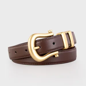 Close-up of premium dark brown women's leather belt with unique gold horseshoe buckle.