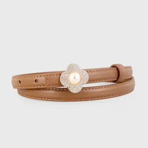 Detailed view of brown leather belt with sparkling rhinestone clover pearl buckle.